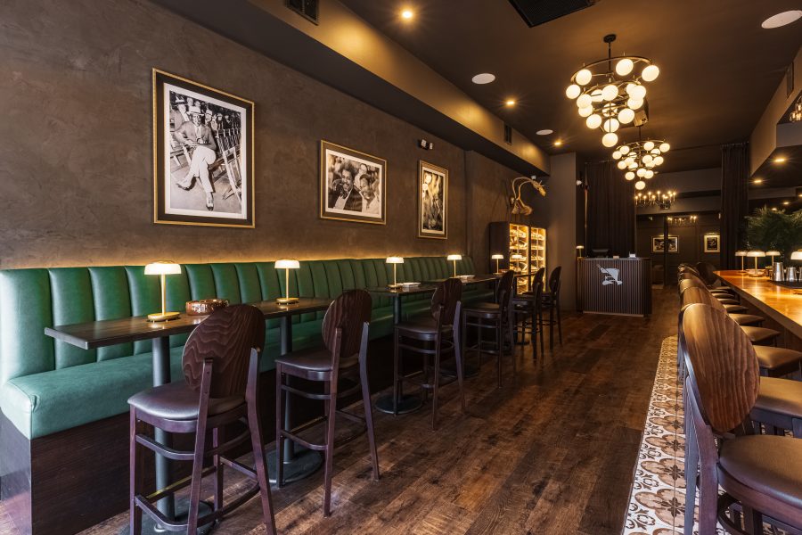 Green banquettes along the bar