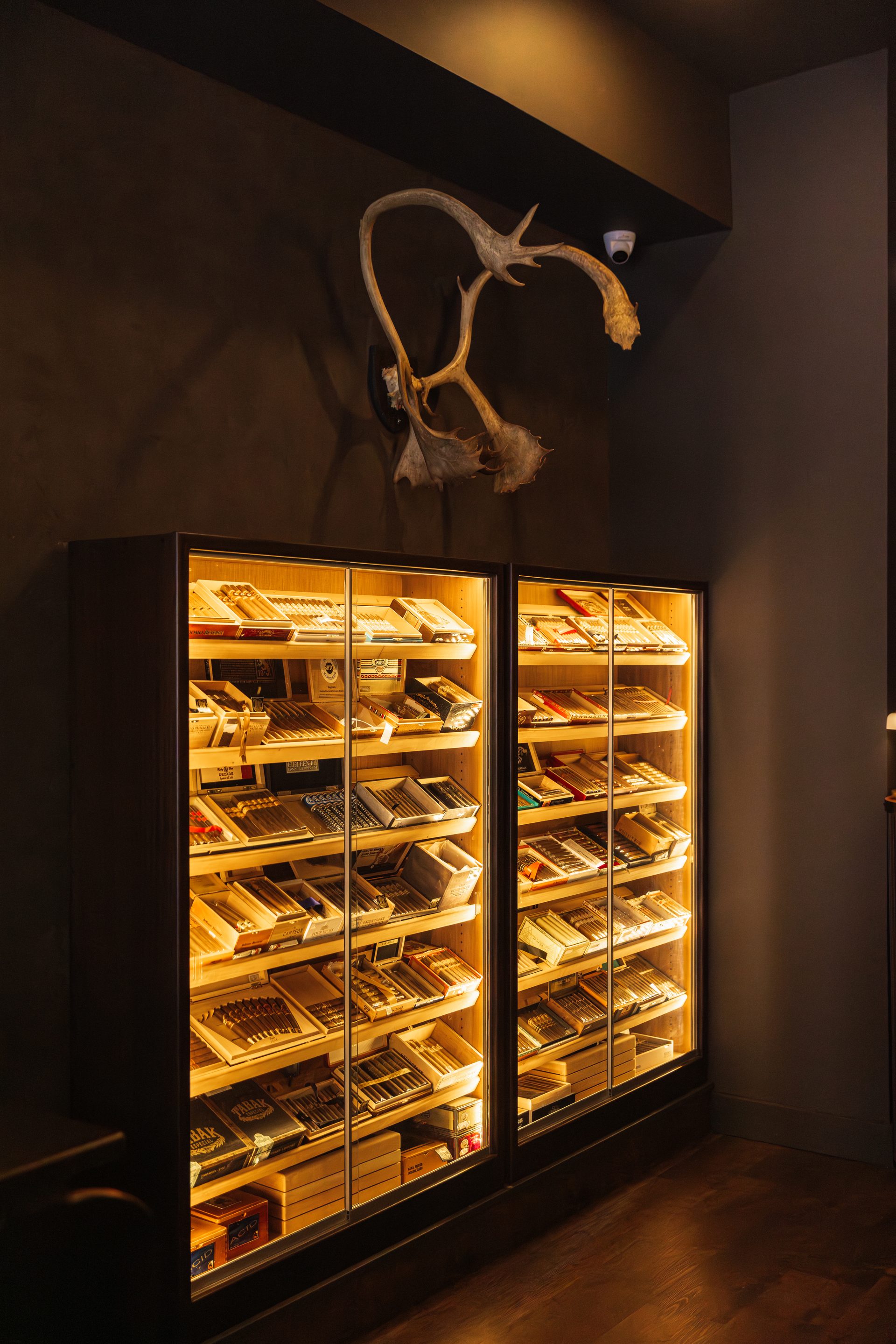 The two cabinet humidors at Legends, illuminated, a caribou mount above